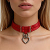 Red choker necklace collar with a heart-shaped leash ring on a BDSM woman
